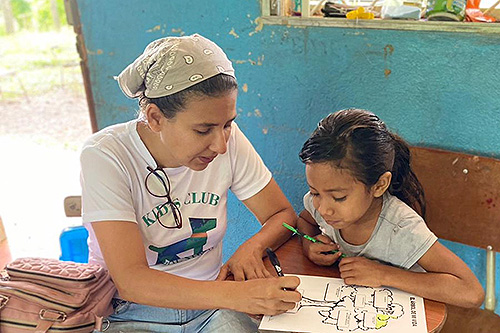 Elisa and Student Elisa doing a worksheet with a student.