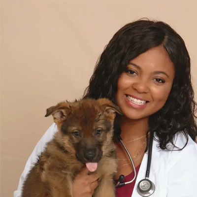 Dr. Tierra Price, founder of  BlackDVM Network, holding a puppy.
