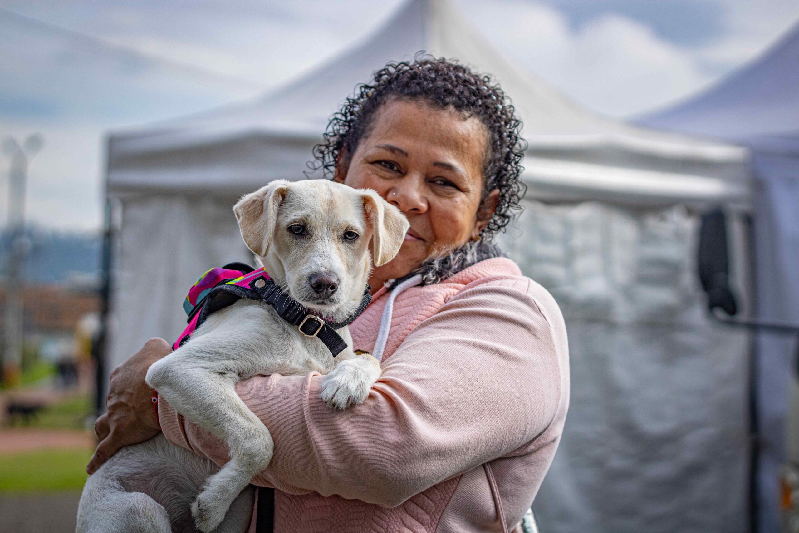 Carmen holds Mia a friendly white dog as they wait for Mia's spay procedure.